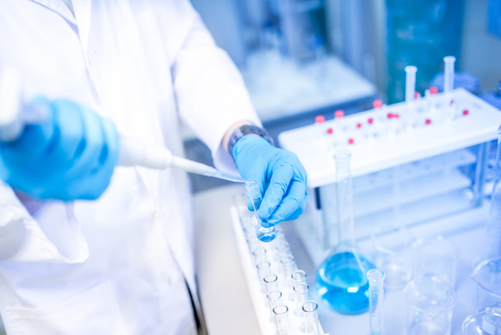 scientist hands with dropper or pipette, examining samples and liquid