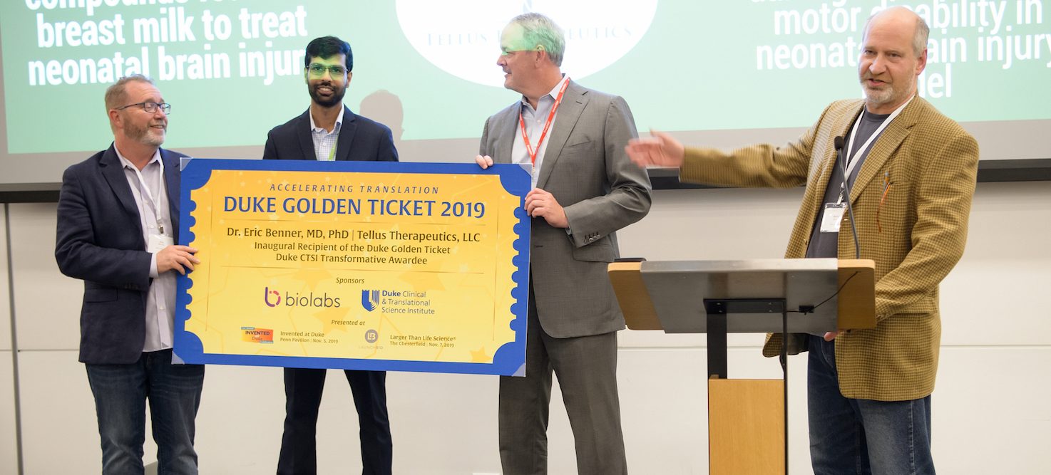 Barry Meyers, Ed Field, and Tarun Saxena presenting BioLabs Golden Ticket to Tellus Therapeutics founder, Eric Brenner