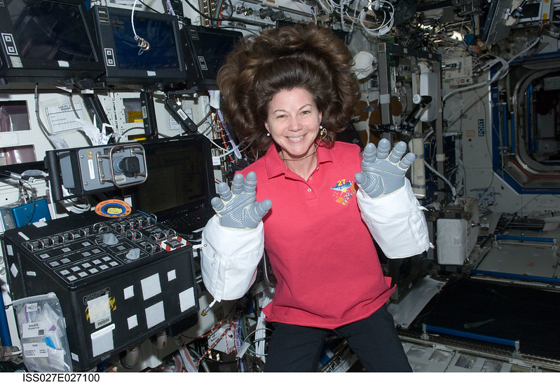 Expedition 27 flight engineer Cady Coleman, wearing Extravehicular Mobility Unit (EMU) gloves, poses for a photo in the Destiny U.S. Laboratory.